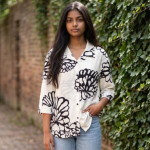 Women's white printed shirt featuring oversized black floral artwork on an ivory base.